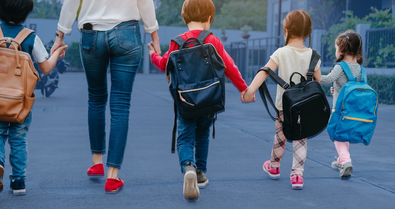 mom with kids walking with backpacks on