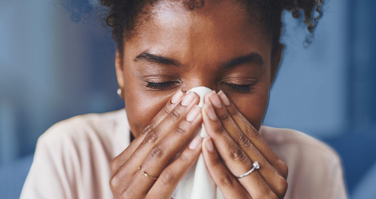 woman blowing her nose into a tissue