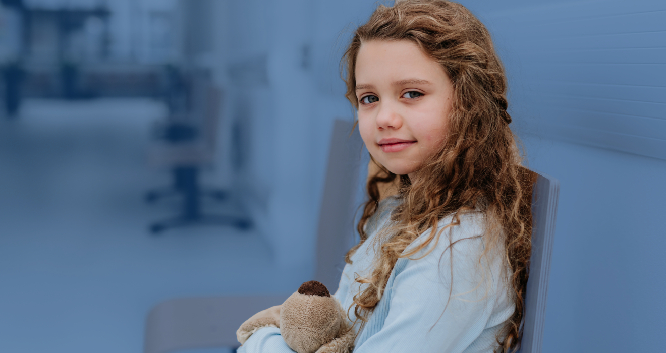 young girl sitting with a stuffed animal