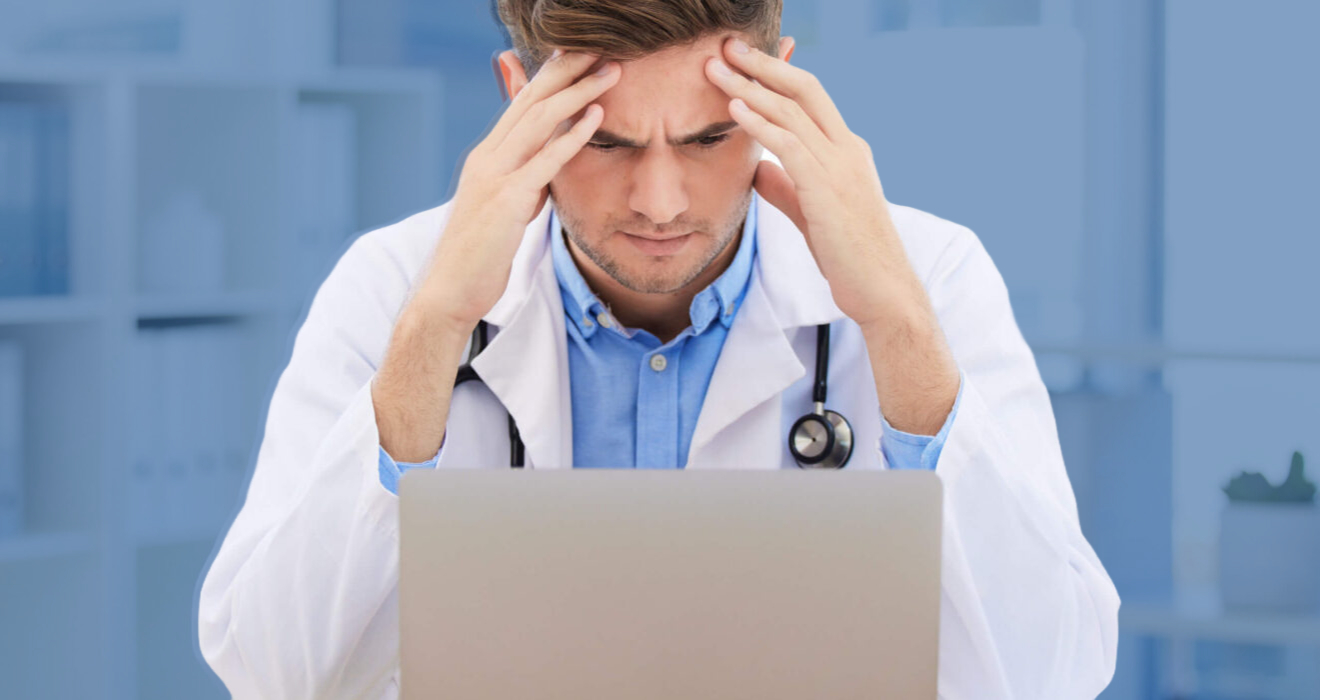 doctor frustrated in front of a laptop