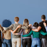 group of people standing in a group with arms around each other