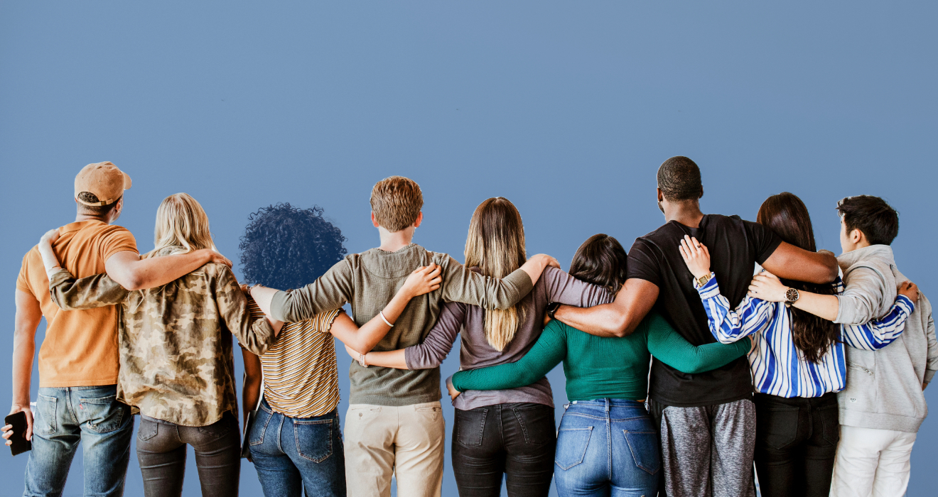 group of people standing in a group with arms around each other