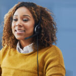 woman in yellow sweater wearing a headset