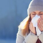 Woman Outside in Coat Blowing Nose