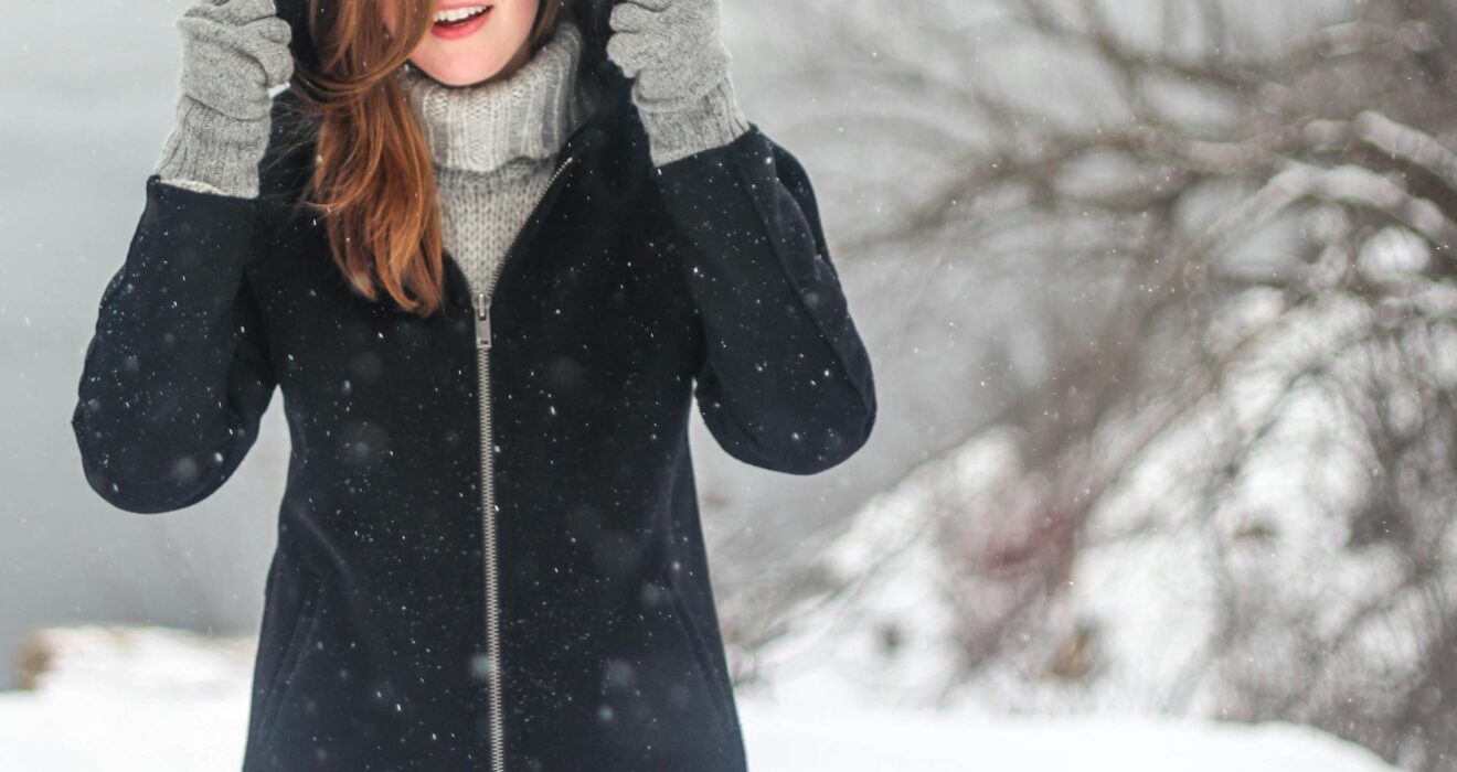 Woman Putting Hood Up Outside in Winter